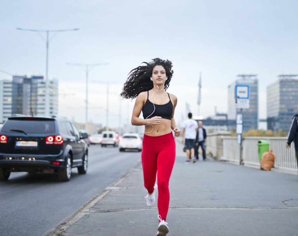 Reebok Rush Runner 4.0 - dziecięce buty do biegania - kobieta biegnąca w czerwonych legginsach
